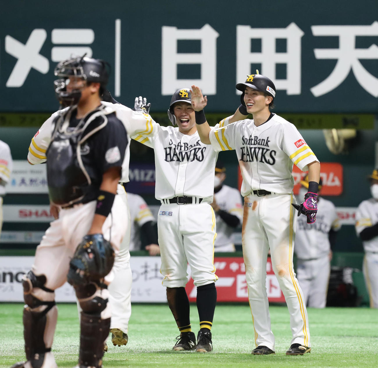 ソフトバンク対ロッテ　4回裏ソフトバンク2死一、二塁、左越え3点本塁打を放った甲斐拓也を笑顔で迎える中村晃と周東（撮影・屋方直哉）