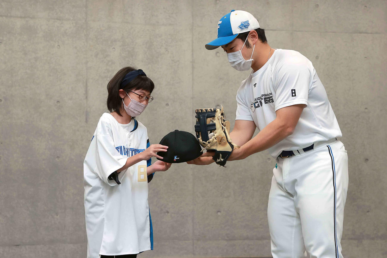 ファーストピッチに挑戦した小学5年生の高橋萌さん（左）にサイン入りの帽子をプレゼントする日本ハム近藤（代表撮影）