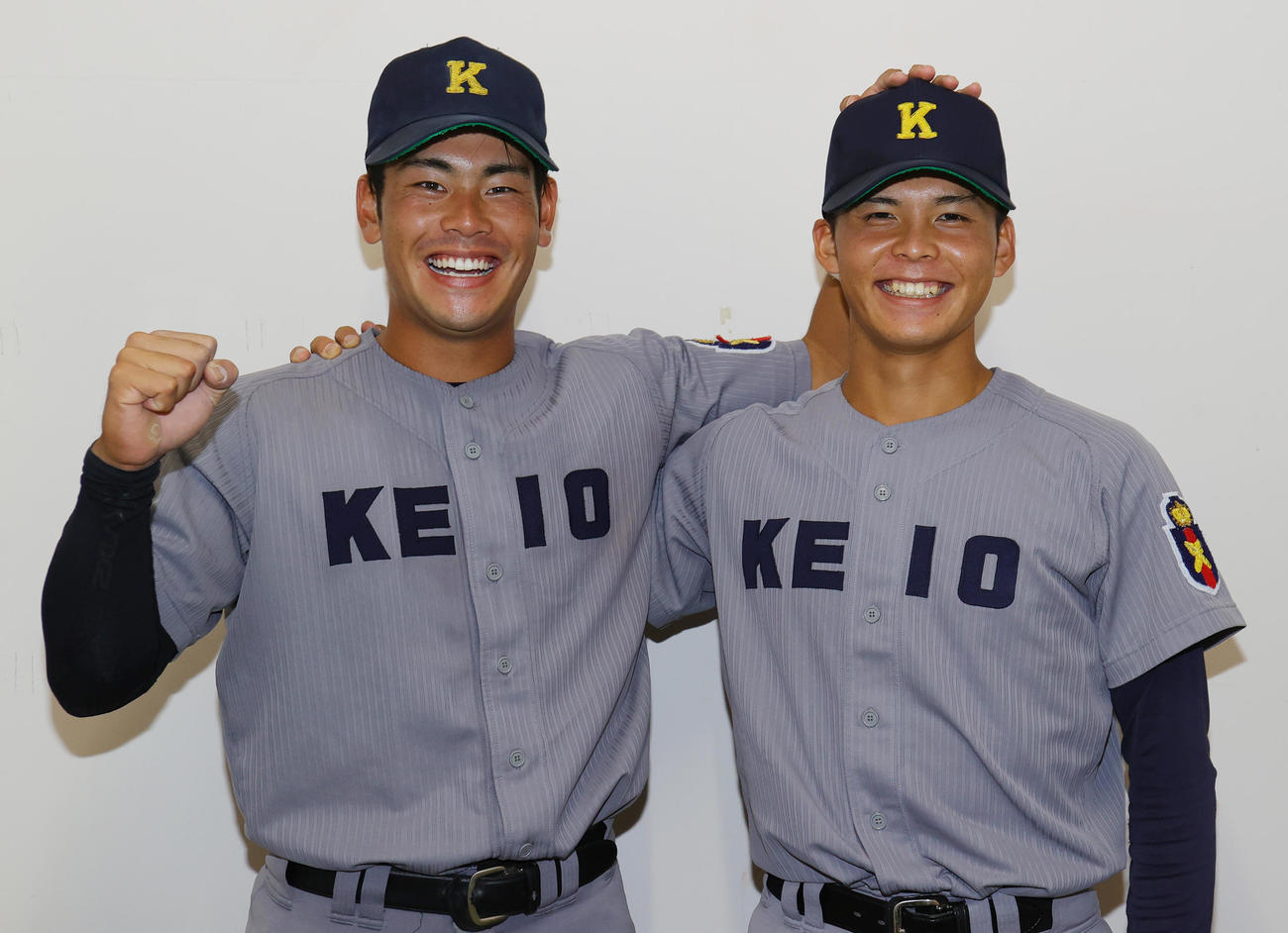 慶大対立大　5回に適時二塁打の慶大4年生、山本（左）は、先発し7回途中3安打1失点と好投した勝利投手の1年生外丸東真の頭をなでながら笑顔でガッツポーズ（撮影・野上伸悟）