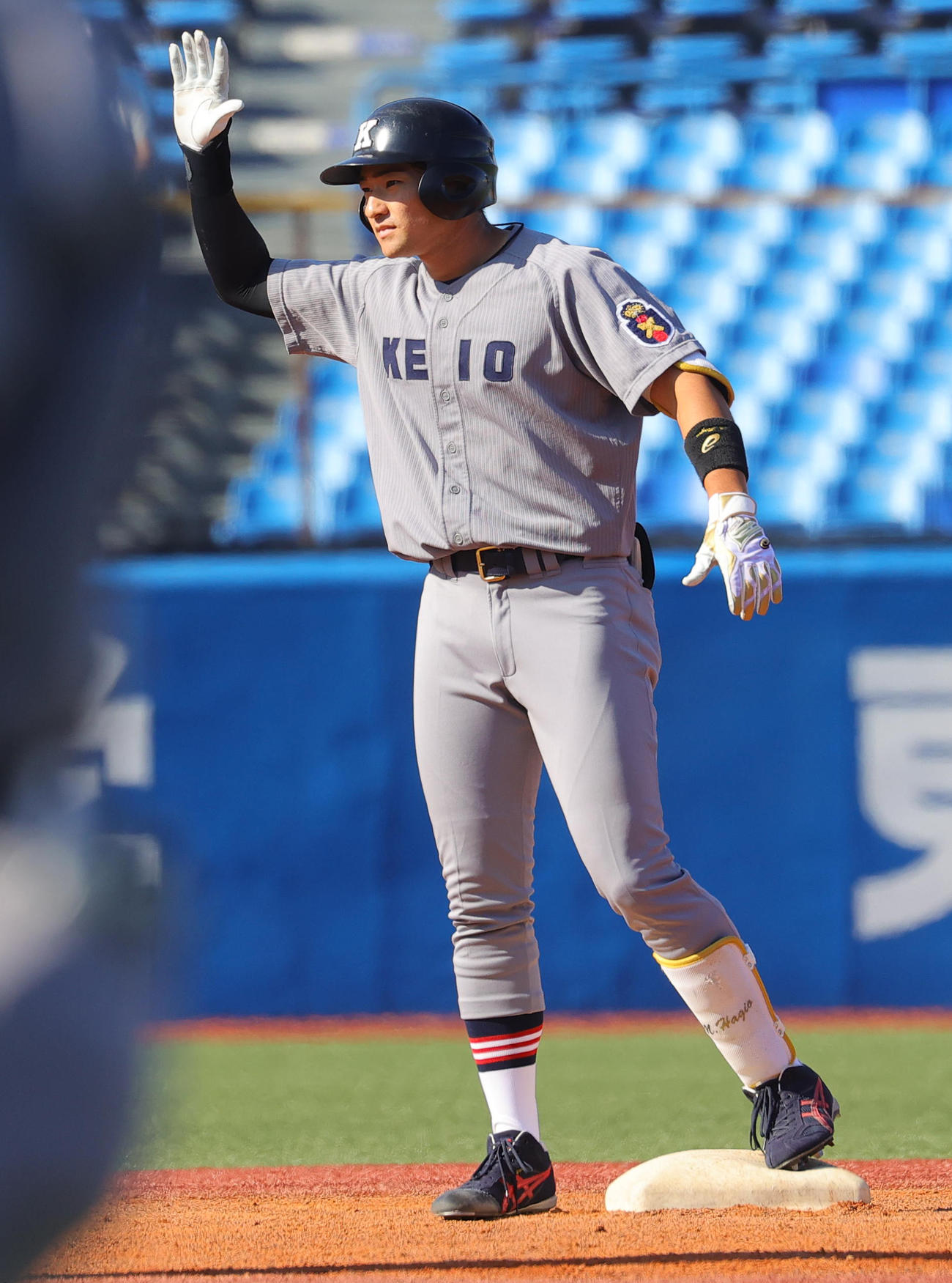 慶大対立大　1回表慶大2死三塁、先制右適時二塁打を放ちベンチに手を挙げる萩尾（撮影・野上伸悟）