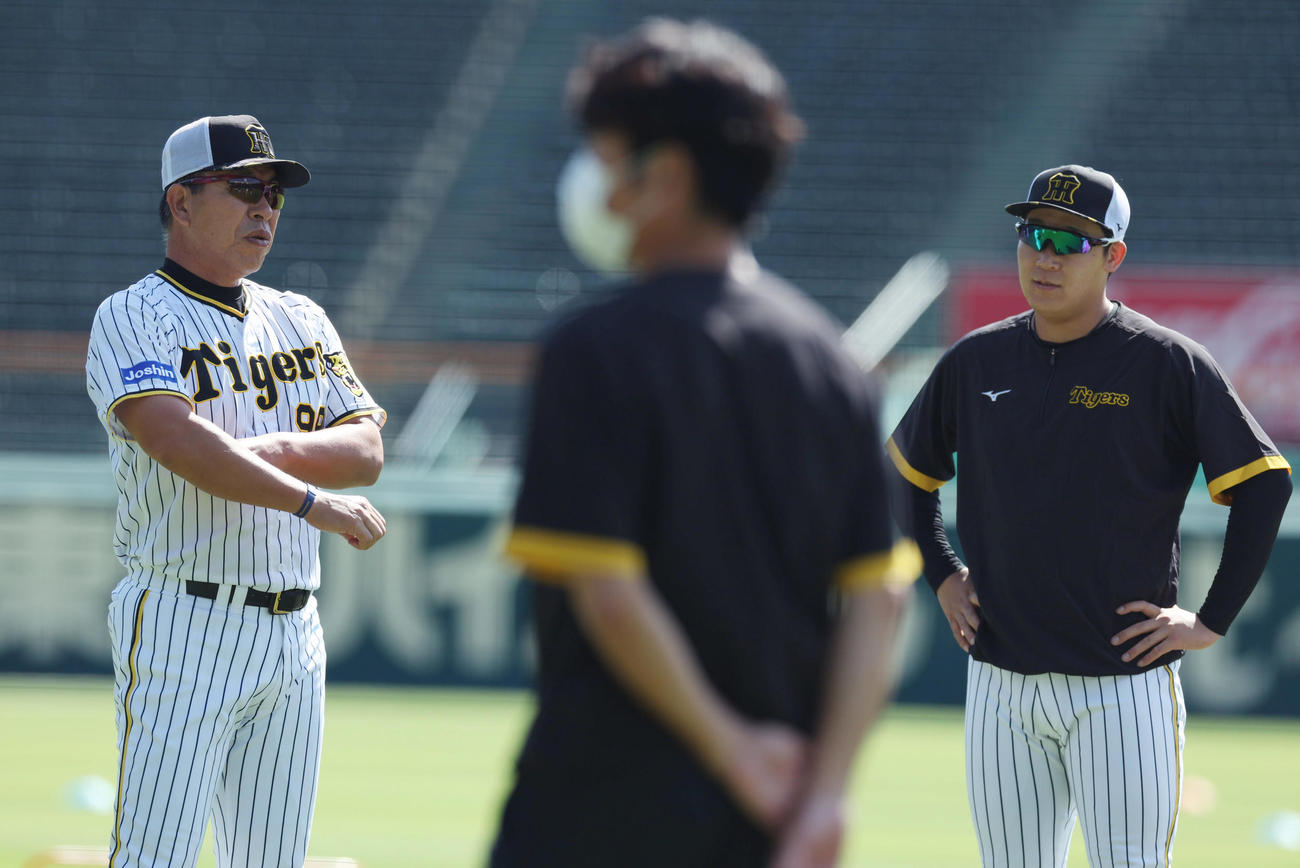 練習前、阪神大山（右）と言葉を交わす井上ヘッドコーチ（撮影・前田充）