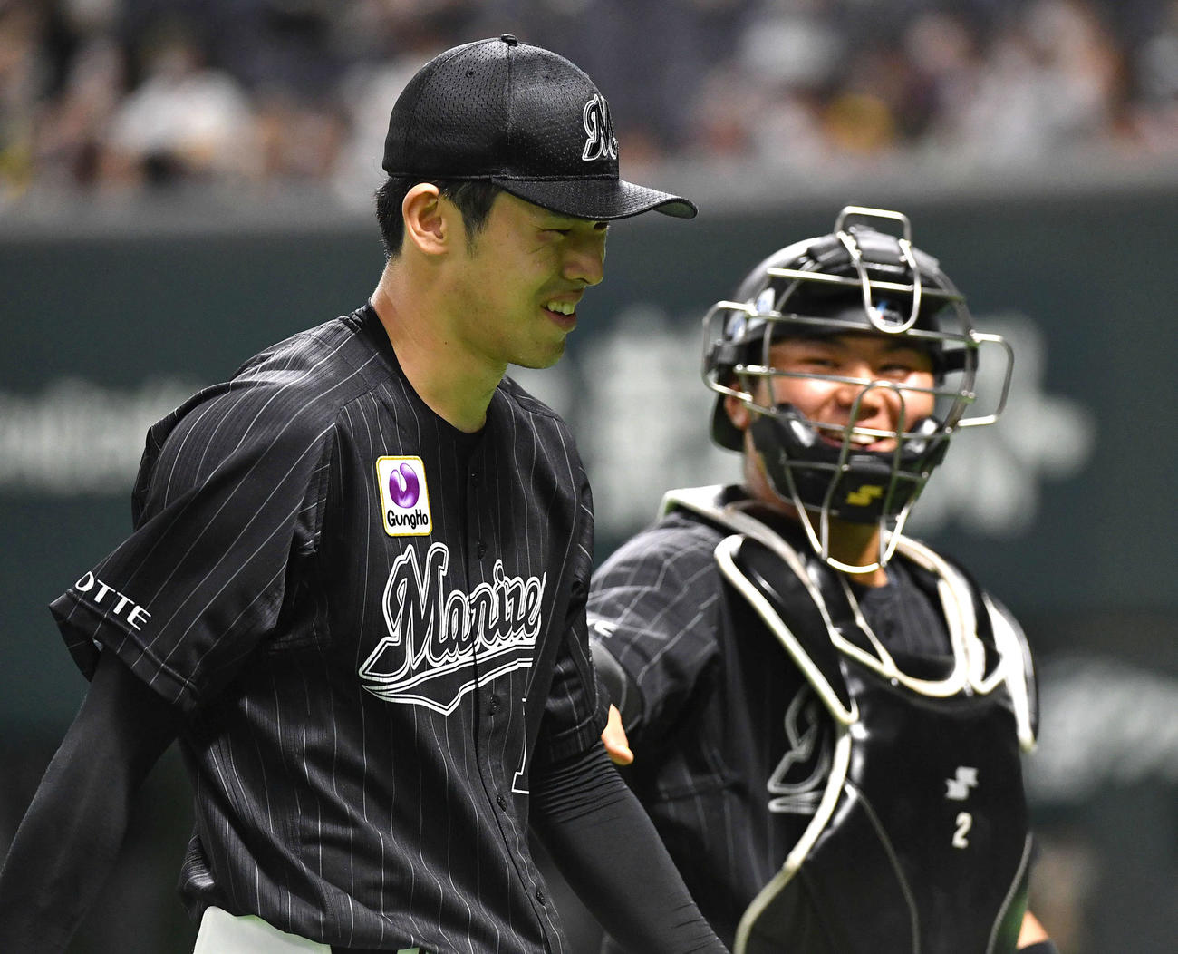 ソフトバンク対ロッテ　4回裏の攻撃を抑え、松川（右）と談笑しながらベンチへ戻る佐々木朗（撮影・岩下翔太）