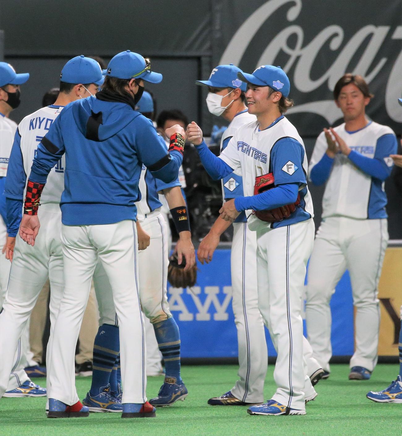 日本ハム対楽天　初セーブを挙げた日本ハム伊藤（手前右）とタッチする新庄監督（撮影・黒川智章）