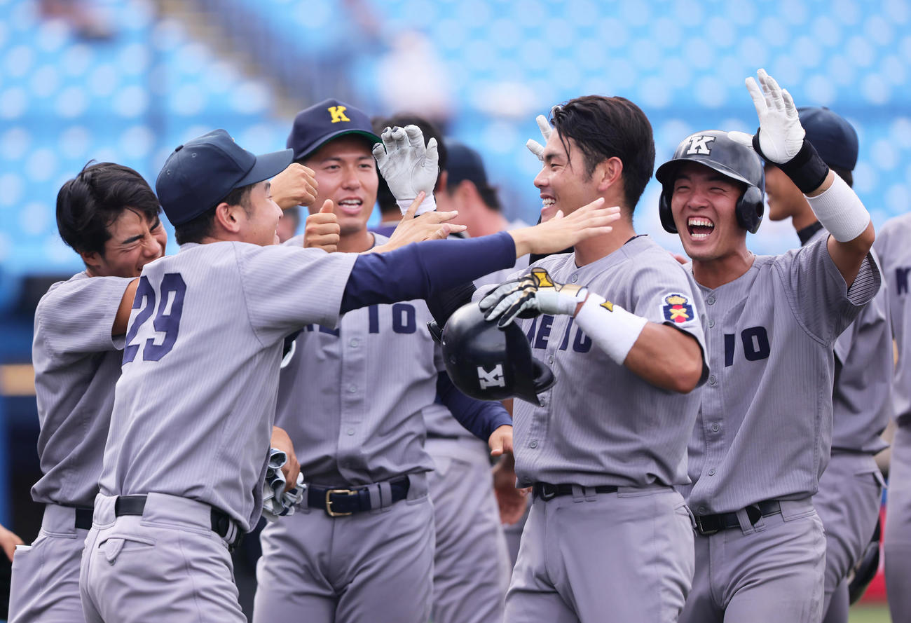 立大対慶大　10回裏慶大2死二、三塁、山本（右から2人目）はサヨナラ3点本塁打を放ちナインの祝福に笑顔を見せる（撮影・足立雅史）