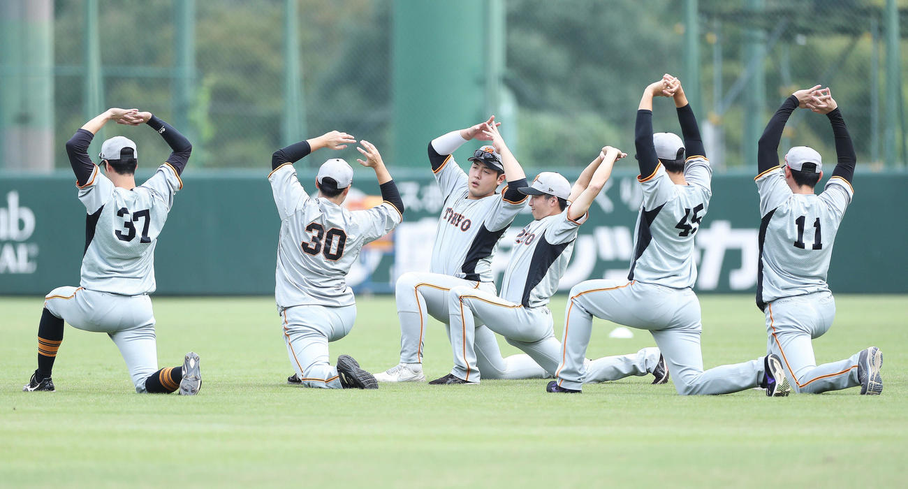 ウオーミングアップする岡本和（中央）ら巨人の選手たち（撮影・河田真司）