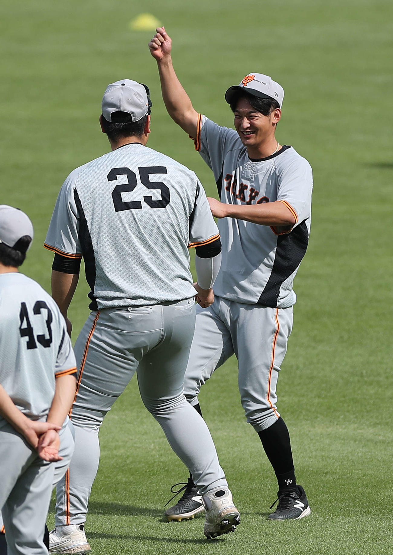 練習開始前、笑顔で言葉を交わす巨人岡本和（左）と吉川（撮影・河田真司）