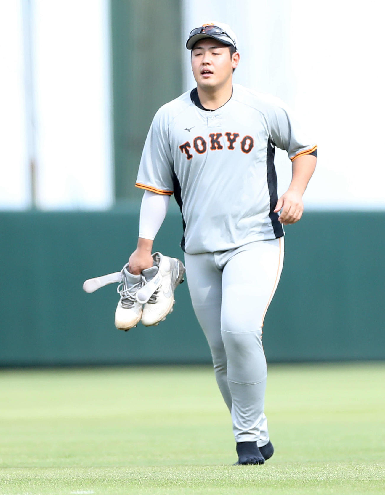 スパイクを脱ぎジョギングする巨人岡本和（撮影・河田真司）