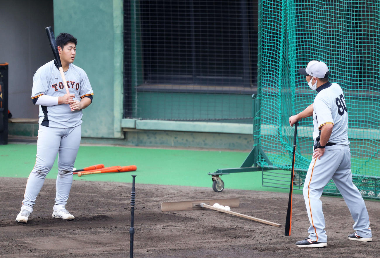 巨人岡本和（左）は阿部作戦兼ディフェンスチーフコーチと言葉を交わす（撮影・河田真司）