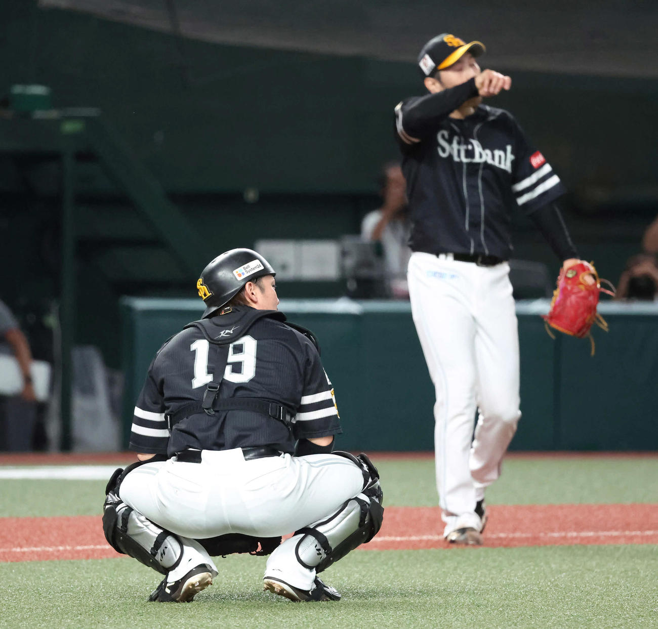 西武対ソフトバンク　5回裏西武無死一塁、源田のバントを二塁へ悪送球して、しゃがむ捕手甲斐。奥は先発石川（撮影・丹羽敏通）