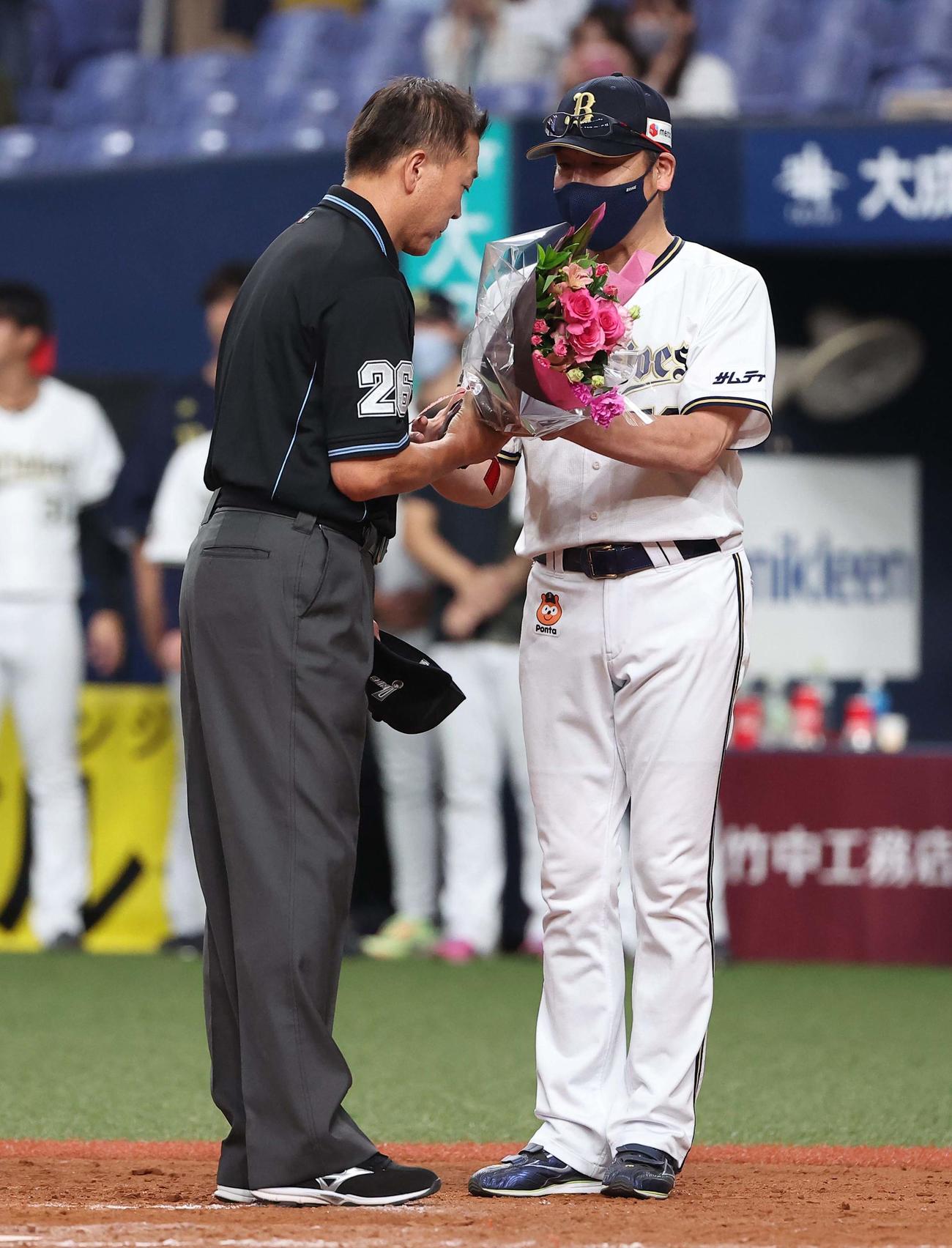 オリックス対楽天　引退する飯塚審判員（左）は中嶋監督から花束を受け取る（撮影・上田博志）