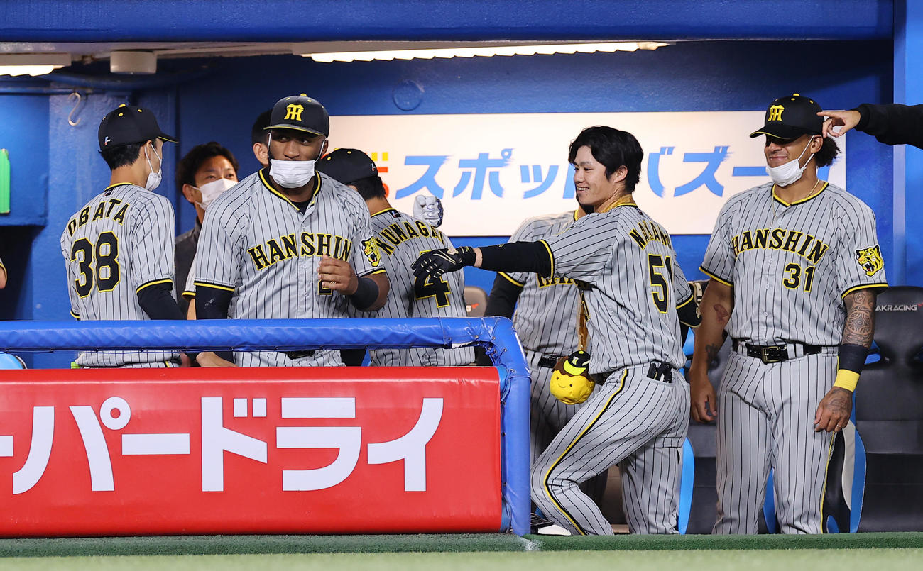 ヤクルト対阪神　1回表阪神無死、2日連続となる先頭打者本塁打を放った中野（中央）はナインの出迎えに笑顔を見せる（撮影・垰建太）