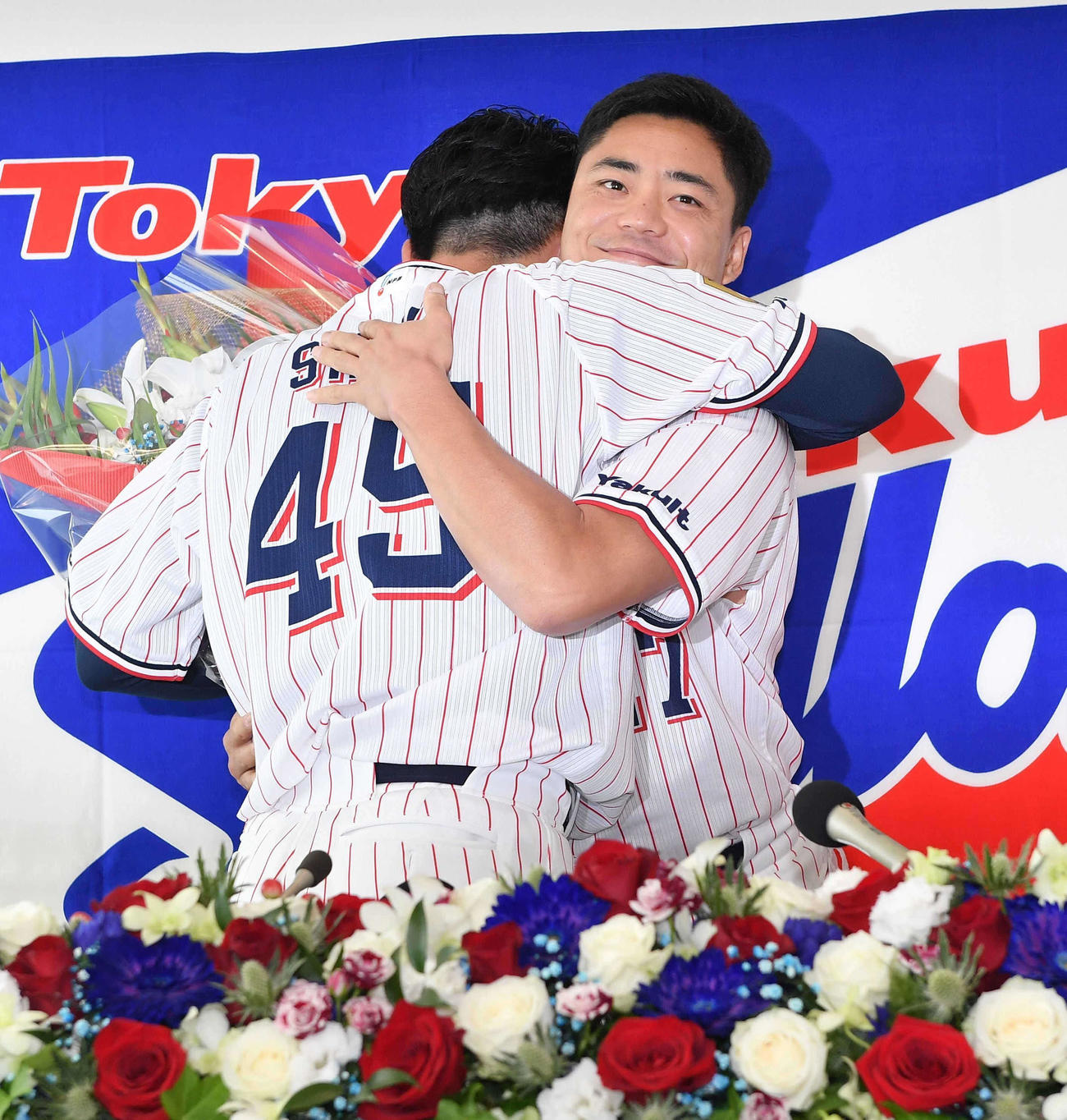 会見にかけつけた中村（右）と抱き合うヤクルト嶋（代表撮影）