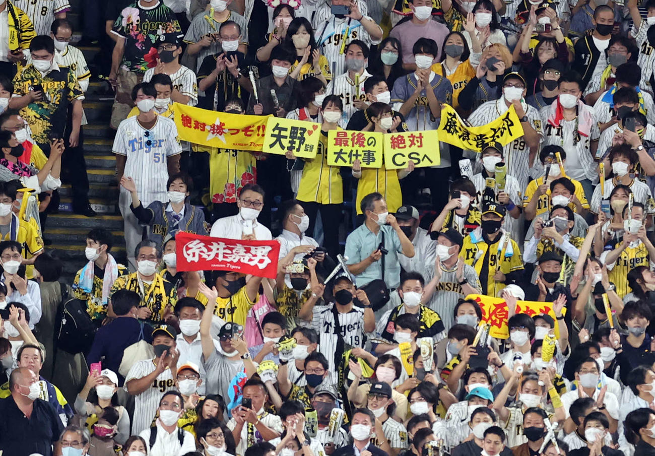 ヤクルト対阪神　2－1で勝利し、「矢野　最後の大仕事　絶対CSへ」のボードを掲げるファン（撮影・浅見桂子）