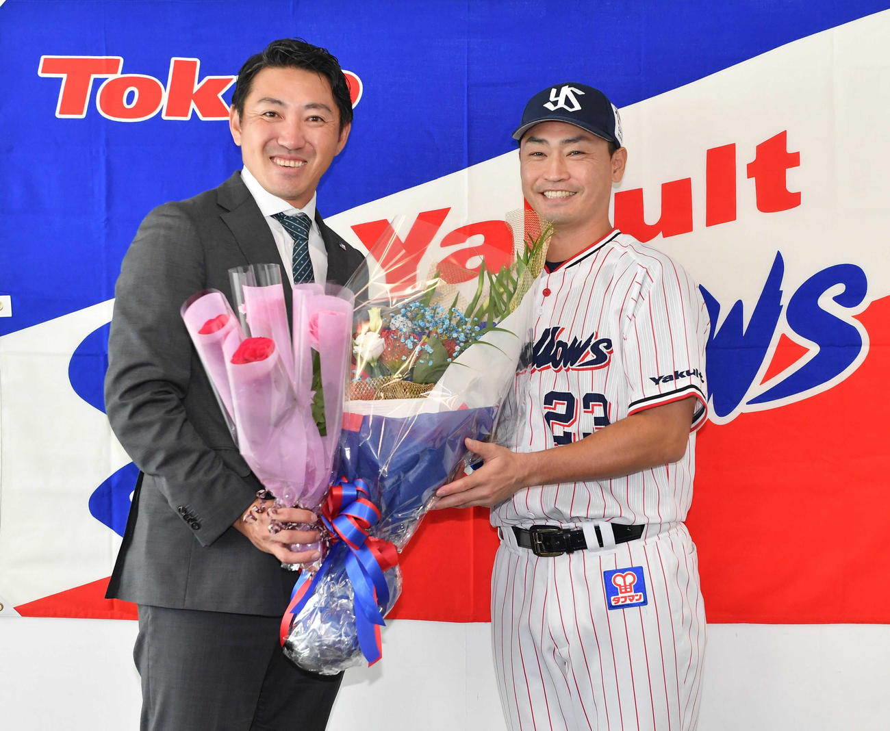 青木（右）から花束を贈られ、笑顔のヤクルト内川（代表撮影）