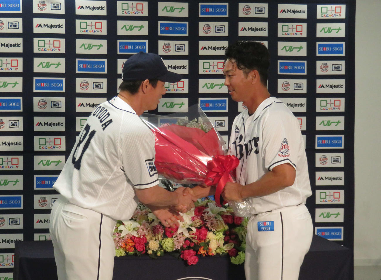 引退会見で豊田投手コーチ（左）から花束を受け取る西武十亀