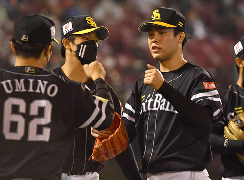 楽天対ソフトバンク 8回裏を無失点に抑え、ナインとタッチを交わしながらベンチへ戻る藤井(撮影・岩下翔太)