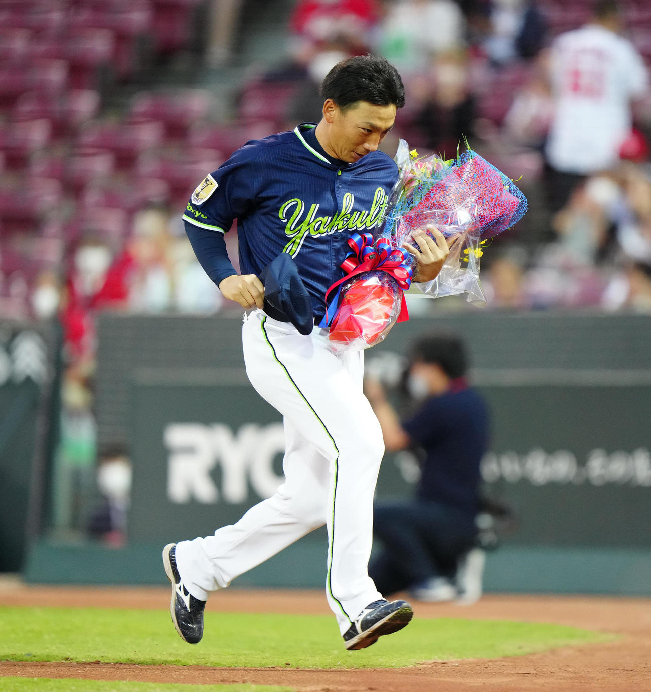 広島対ヤクルト　試合前、広島会沢から花束を受け取り、ベンチに引き揚げるヤクルト嶋捕手兼コーチ補佐（撮影・江口和貴）