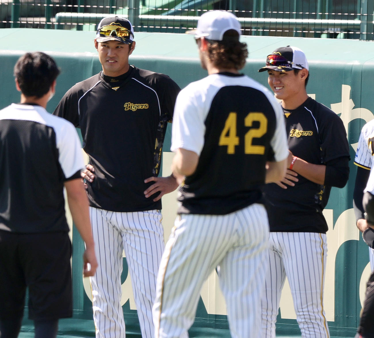 練習前、円陣でリラックスした表情を見せる阪神藤浪（左）と西純（撮影・上山淳一）