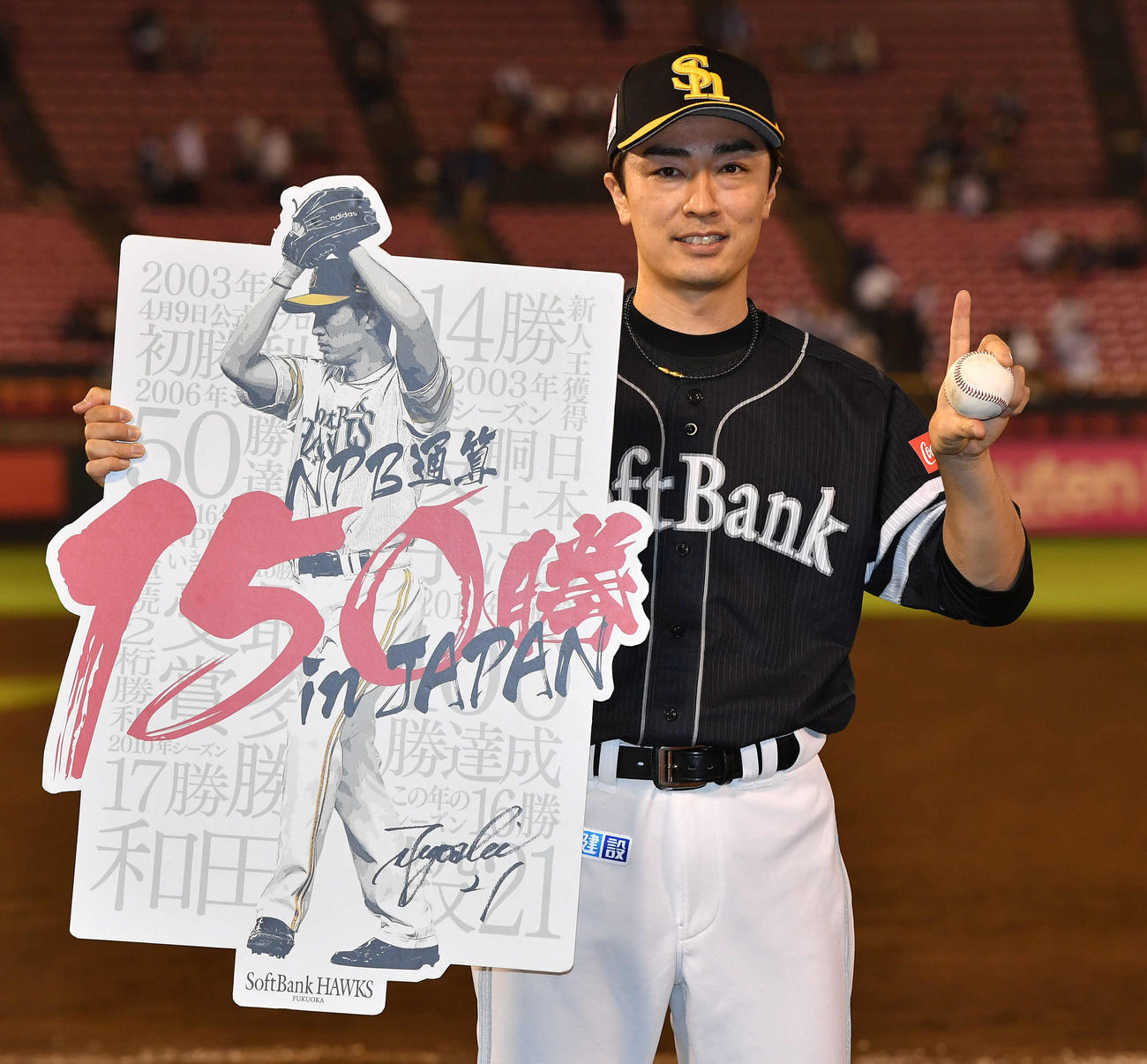 楽天対ソフトバンク　NPB通算150勝を達成した和田は、記念ボードと記念球を手に指でM1のポーズをつくる（撮影・岩下翔太）