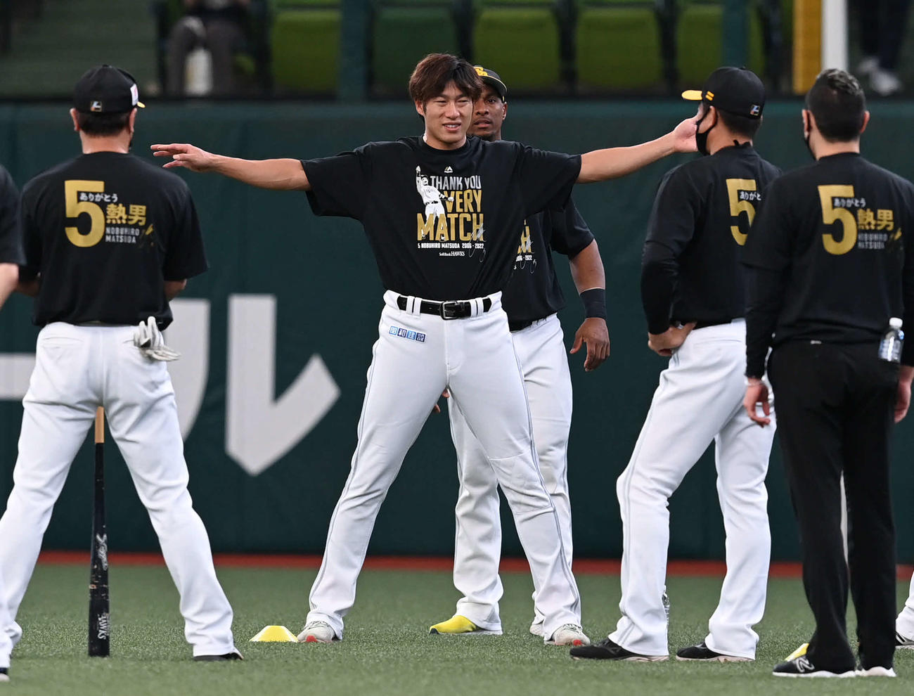 西武対ソフトバンク　試合前の練習中にソフトバンク柳田（左から2人目）は松田の特製Tシャツを着込んでストレッチ（撮影・山崎安昭）