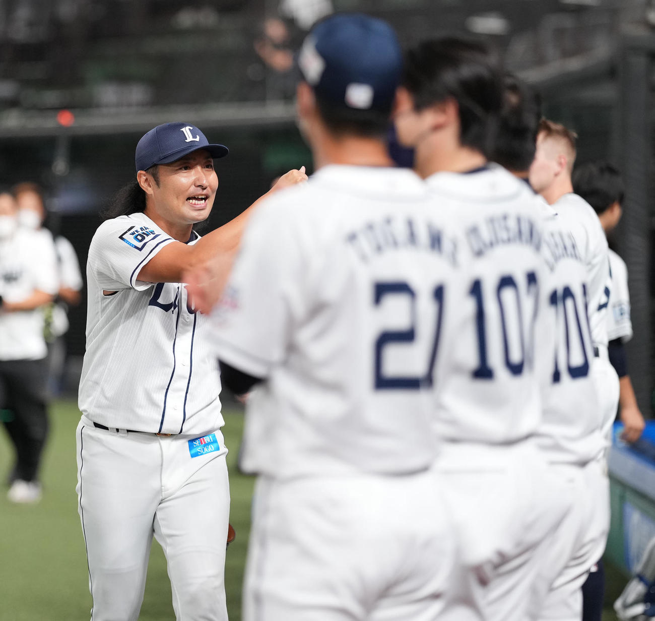 西武対日本ハム　引退を表明し、セレモニアルピッチを終えた西武武隈（左）はナインとタッチを交わす（撮影・鈴木みどり）