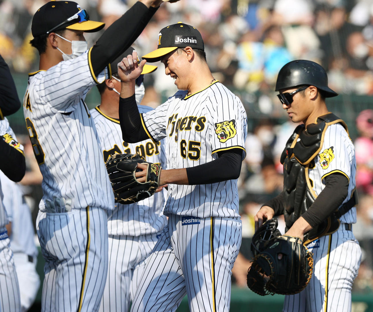 阪神対ヤクルト　4回に登板の阪神湯浅（右から2人目）は無失点に抑え笑顔を見せる（撮影・上山淳一）