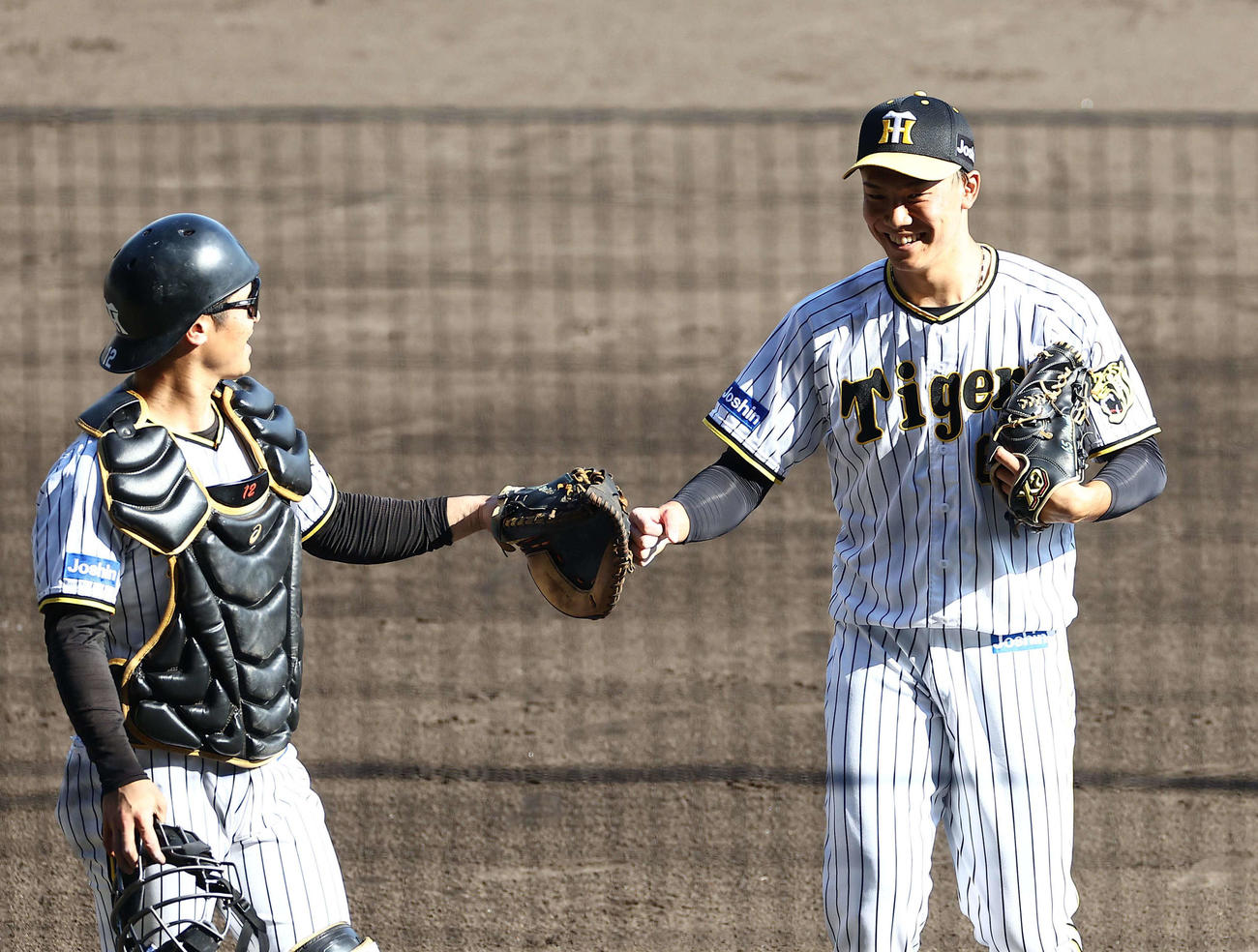阪神対ヤクルト　2番手の湯浅（右）は1イニングを無失点に抑え坂本とグータッチする（撮影・上田博志）