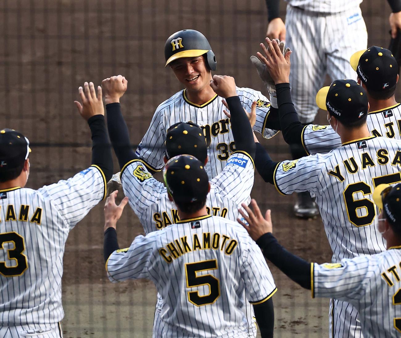 阪神対ヤクルト　9回裏阪神2死一、二塁、同点適時打を放った栄枝（中央）はナインの出迎えに笑顔を見せる（撮影・上田博志）