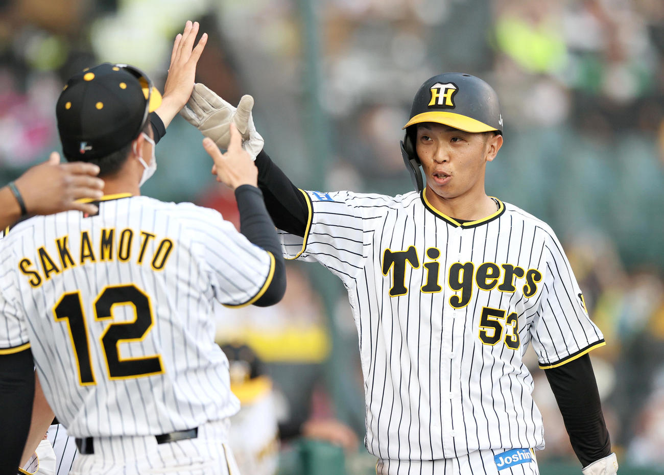 阪神対ヤクルト　9回裏阪神1死一、二塁、梅野は左前適時打で生還の島田（右）はベンチのナインの出迎えを受ける（撮影・上山淳一）