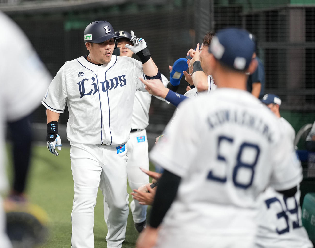西武対日本ハム　4回裏西武2死一塁、先制の左越え2点本塁打を放った中村（左）はナインと笑顔でハイタッチ（撮影・鈴木みどり）