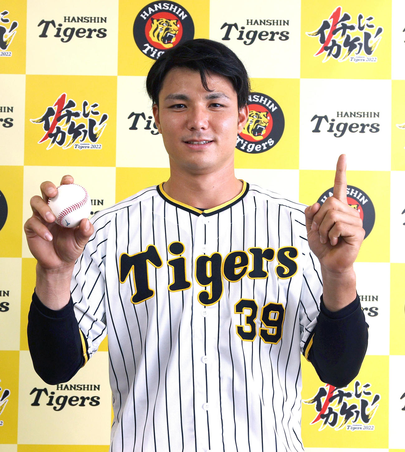 阪神栄枝はプロ初安打を記録し、ボールを手に笑顔を見せる
