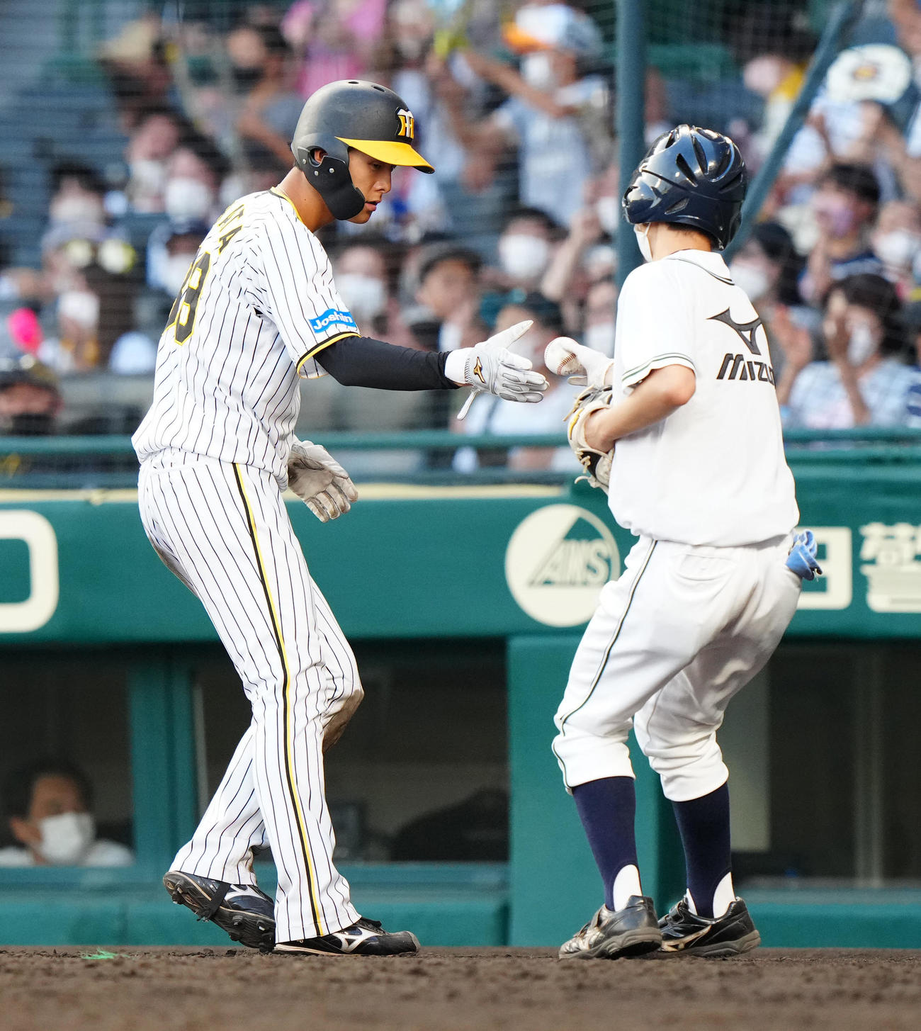 阪神対ヤクルト　9回裏阪神2死一、二塁、同点適時打を放った栄枝の記念球を受け取る小幡（撮影・江口和貴）