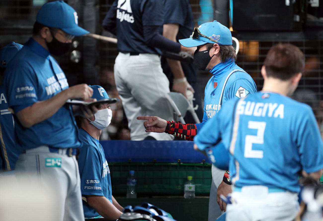 西武対日本ハム　監督席に座る松本剛（左後方）に声をかける新庄監督（撮影・佐藤翔太）