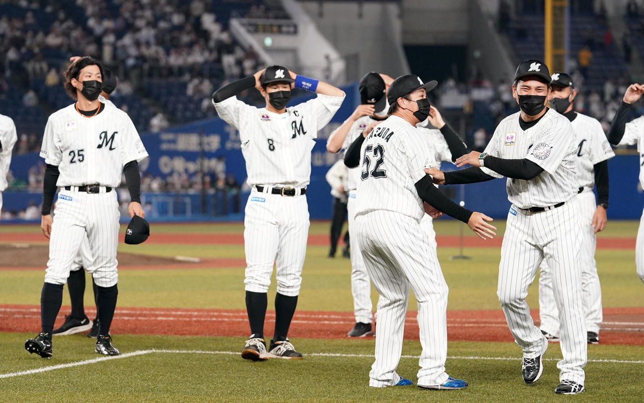 ロッテ対ソフトバンク　シーズン最終戦セレモニーを終え、選手たちからの胴上げを笑顔で遠慮するロッテ井口監督（右）（撮影・横山健太）
