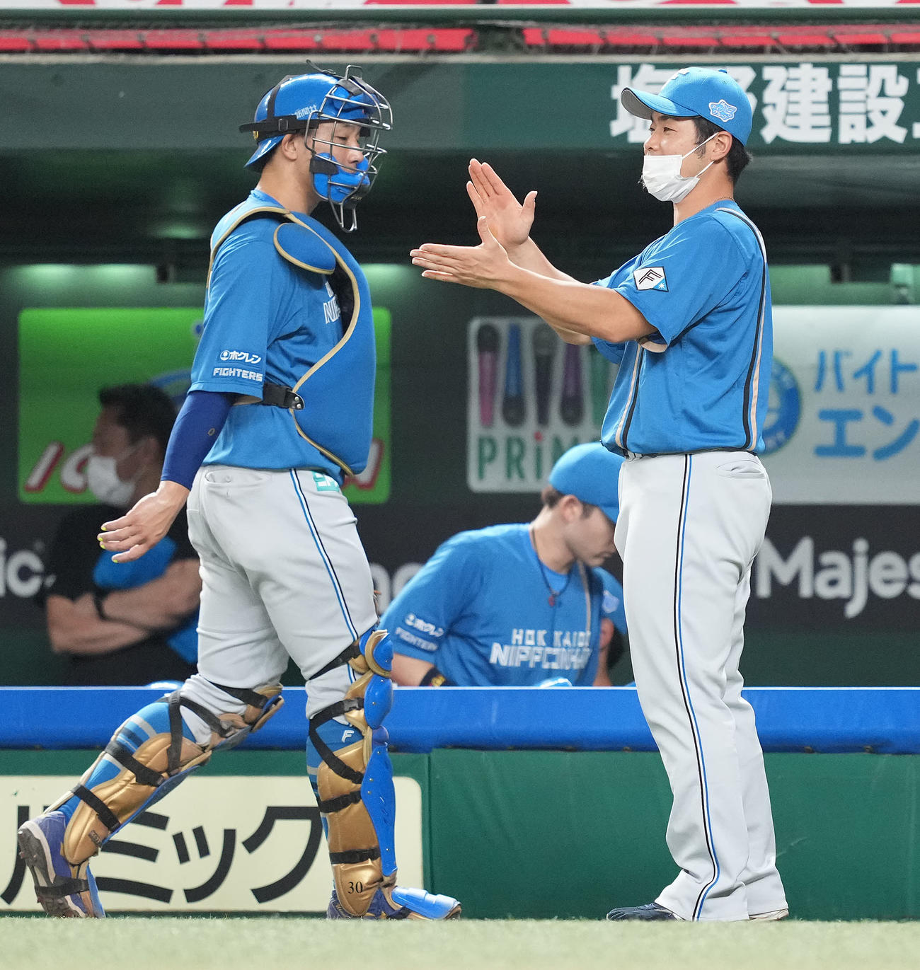 西武対日本ハム　3回裏を終えた宇佐見（左）らナインを拍手で迎える日本ハム近藤（撮影・鈴木みどり）