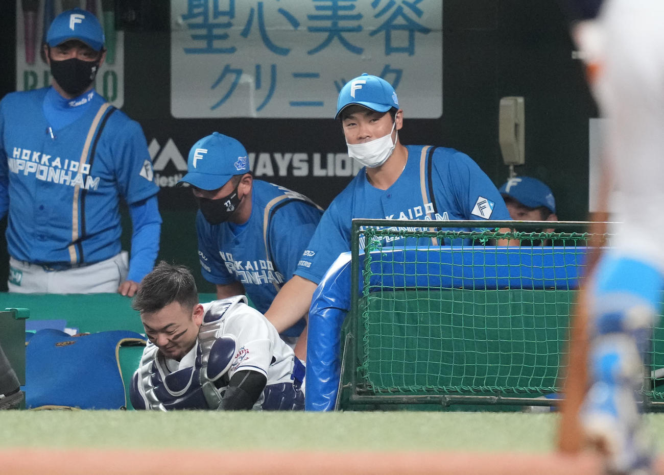 西武対日本ハム　5回表日本ハム1死一塁、杉谷の打球を追いかけ日本ハムベンチへ突っ込む捕手森（左下）に笑顔の近藤（右）（撮影・鈴木みどり）