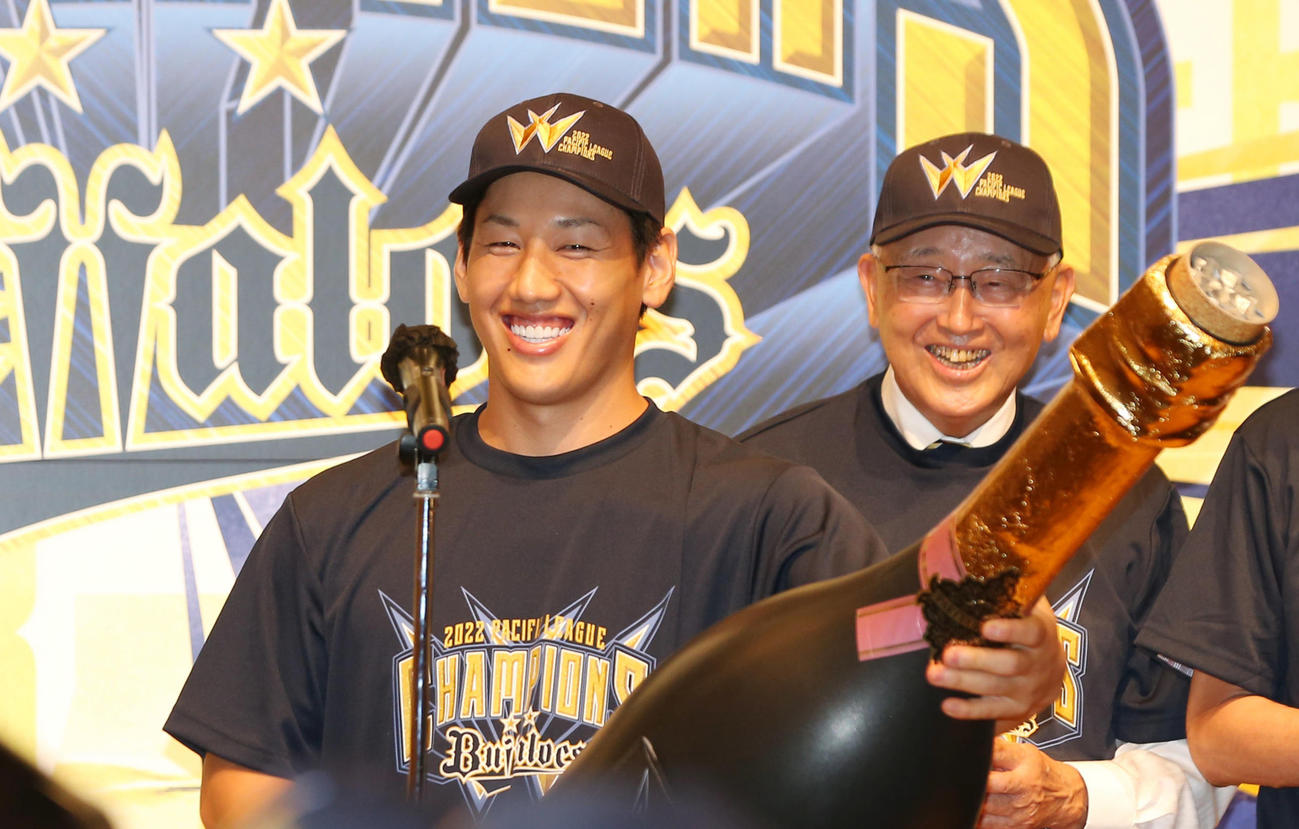 祝勝会で巨大クラッカーを手に笑顔を見せるオリックス吉田正。右はオリックス宮内オーナー（撮影・前田充）