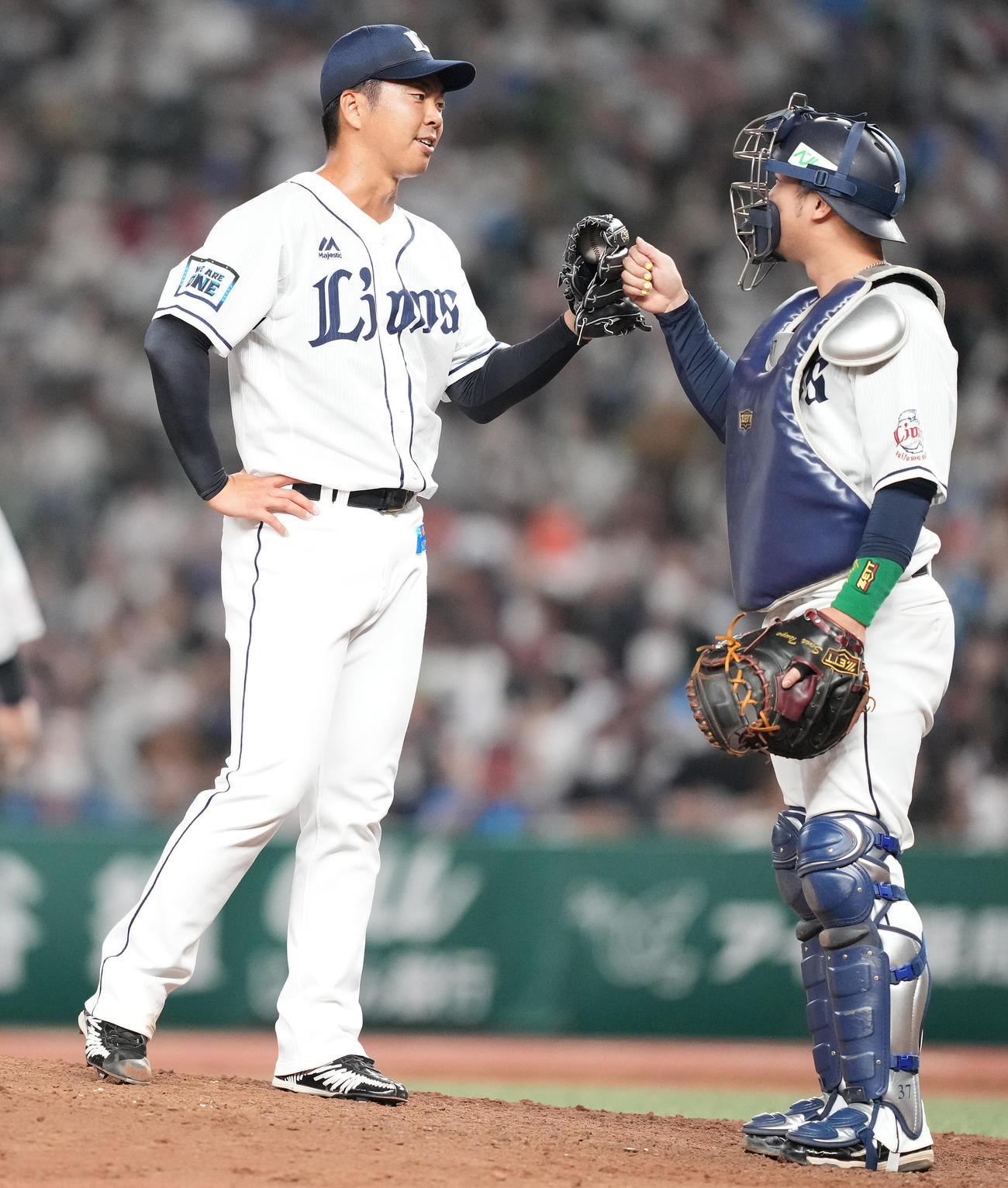 西武対日本ハム　7回表日本ハム無死、石井を空振り三振に仕留め引退登板を終えた十亀（左）は柘植とタッチを交わす（2022年10月2日撮影）