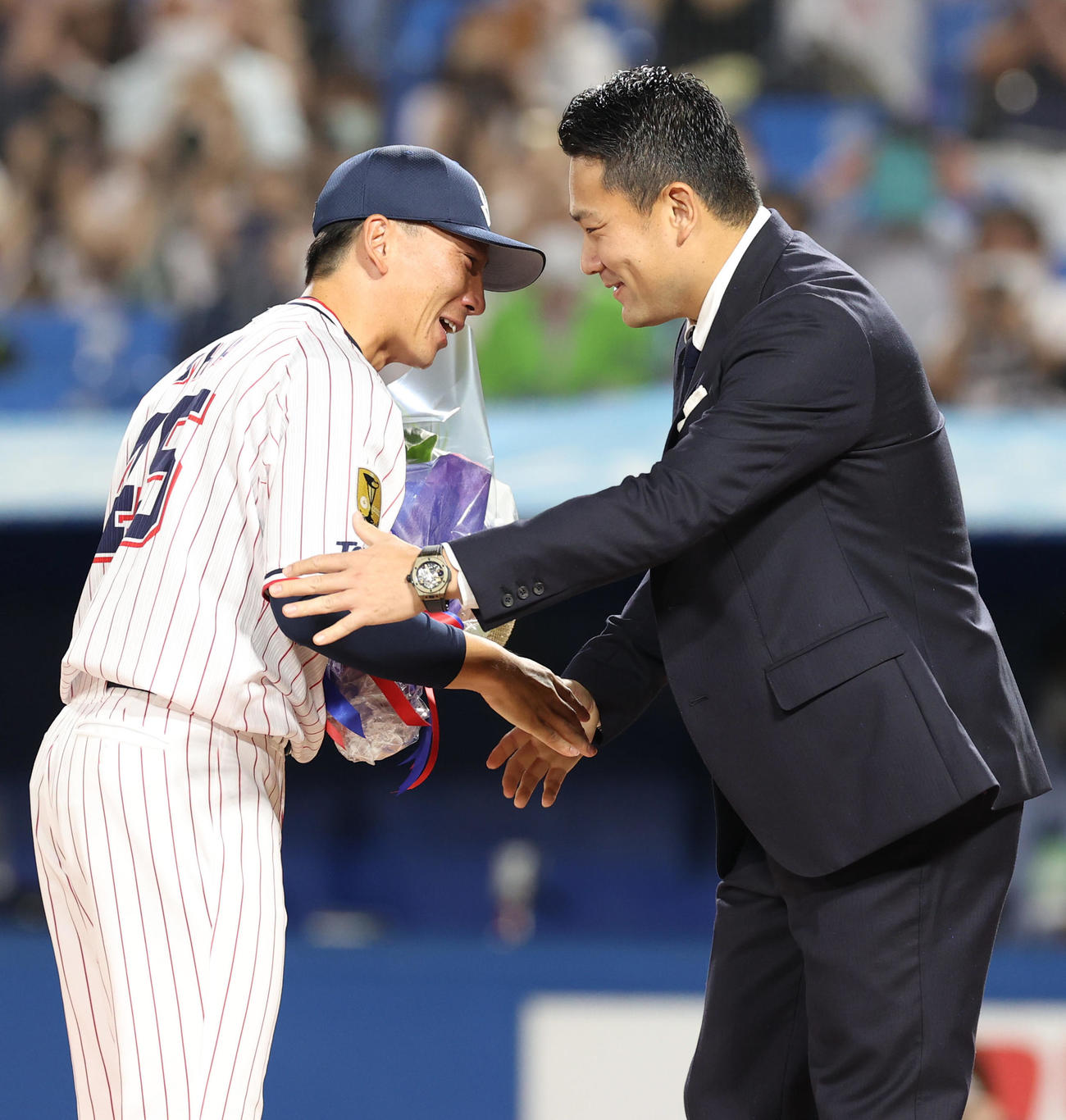 ヤクルト対DeNA　試合後の引退セレモニーでサプライズゲストの楽天田中（右）から花束を受け取る嶋（撮影・狩俣裕三）
