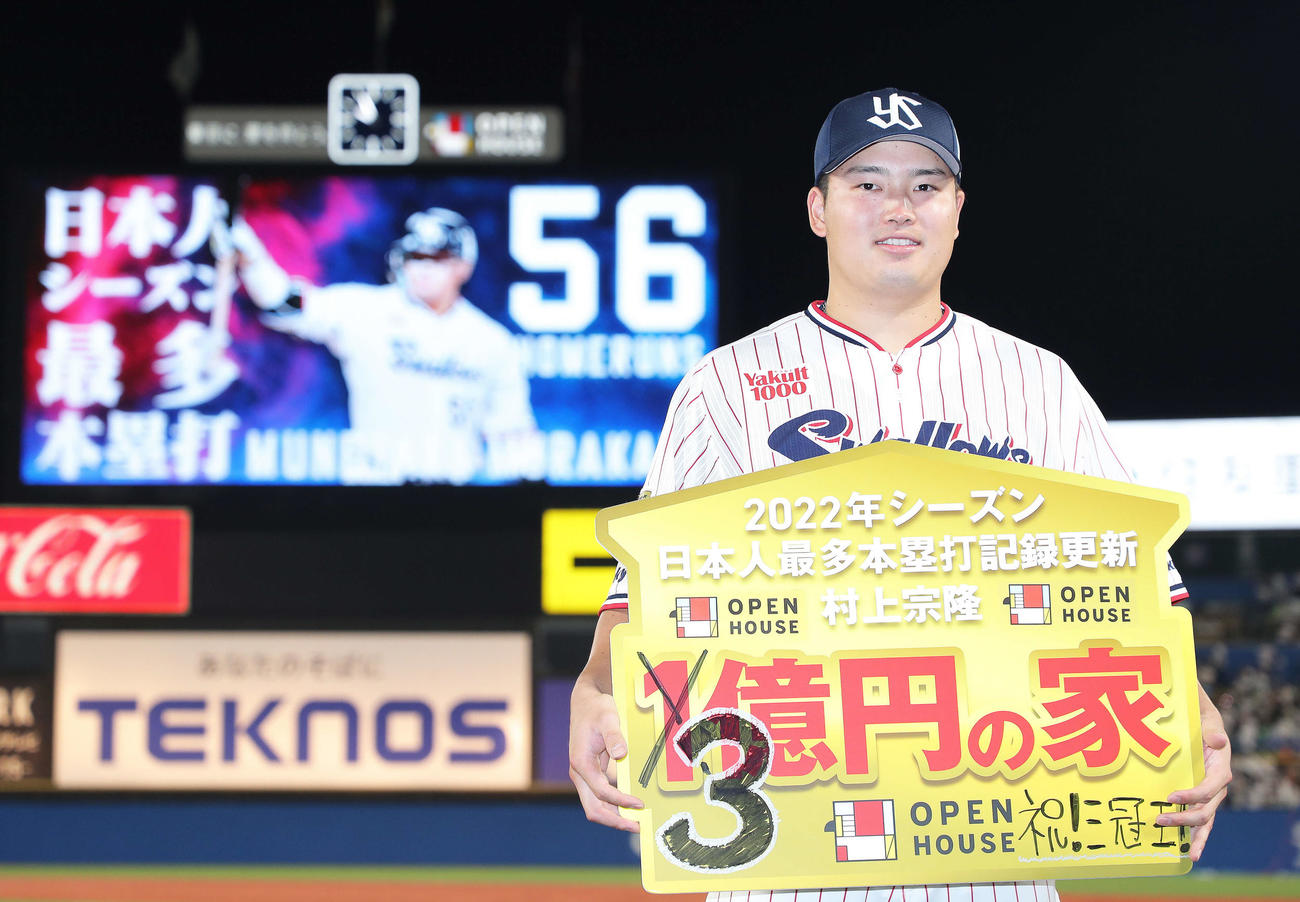 シーズン56号本塁打の日本選手最多記録を更新し、「3億円」に変更されたボードを手に笑顔を見せるヤクルト村上（撮影・河田真司）