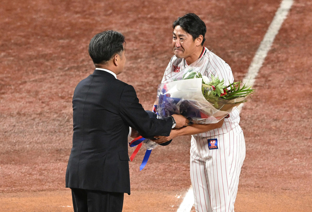 ヤクルト対DeNA　引退セレモニーで工藤氏（左）からサプライズで花束を受け取る内川（撮影・滝沢徹郎）