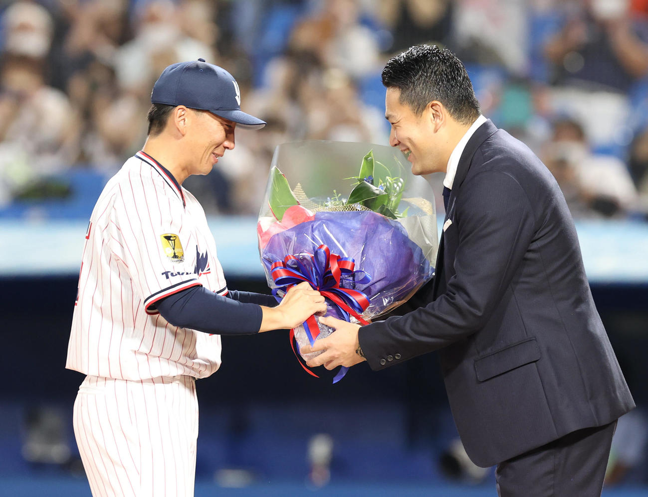 ヤクルト対DeNA　試合後の引退セレモニーでサプライズゲストの楽天田中（右）から花束を受け取る嶋（撮影・狩俣裕三）