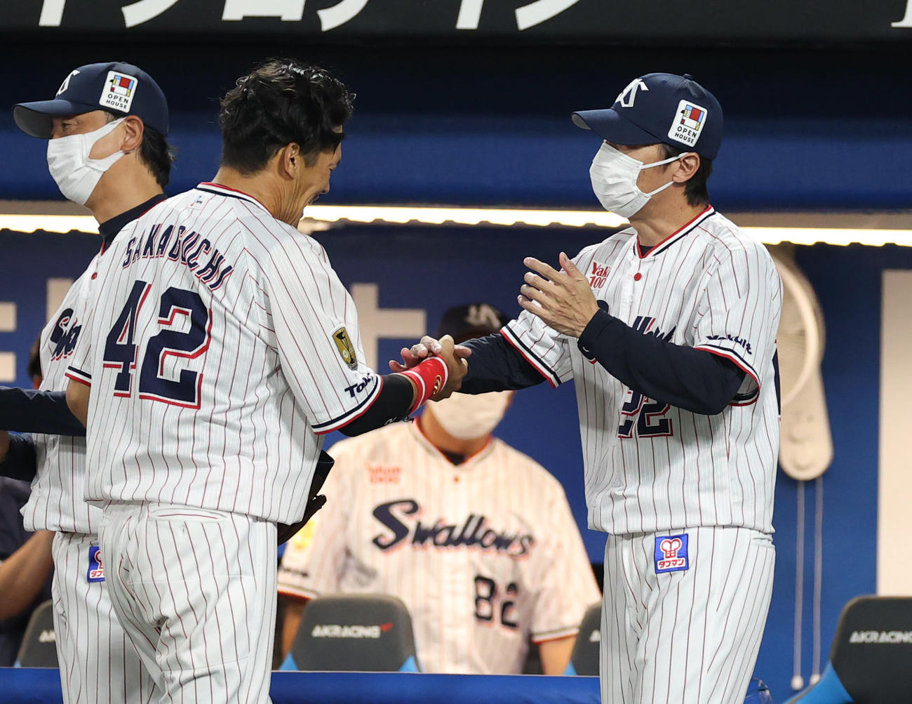 ヤクルト対DeNA 4回表、守備交代で現役最後の出場となり、高津監督（右）と握手を交わす坂口（撮影・狩俣裕三）