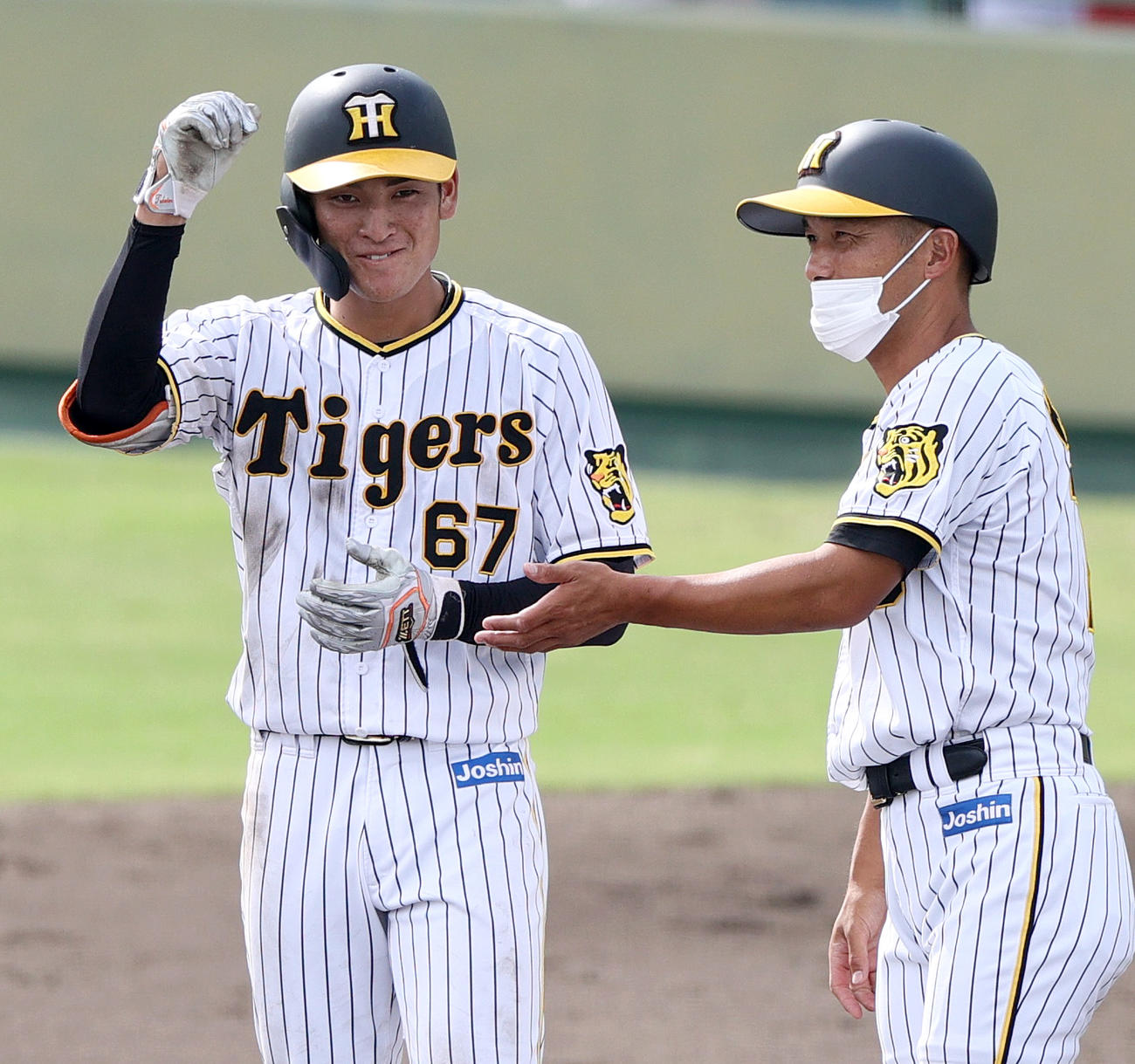 練習試合阪神対日本生命　5回裏阪神2死三塁、高寺（左）は左前適時打を放ち笑顔を見せる（撮影・上山淳一）