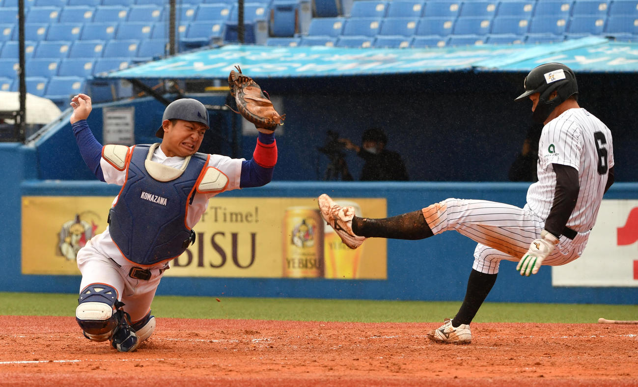 亜大対駒大　3回表亜大無死満塁、山下の中犠飛で三塁走者藤江が生還する。左は岩本捕手（撮影・柴田隆二）