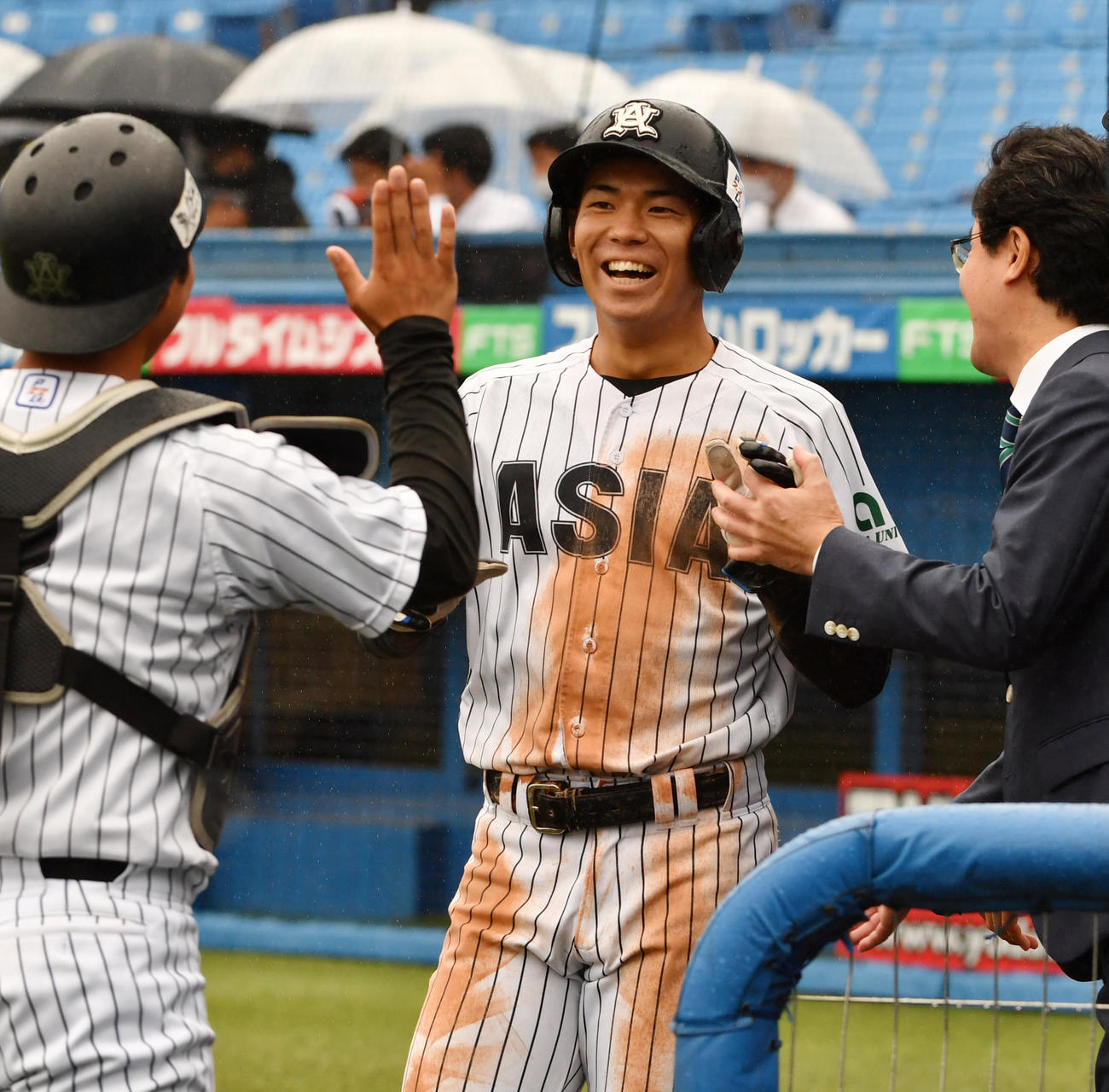 亜大対駒大　5回表亜大1死一、二塁、田中幹の左中間適時二塁打で小山が生還しナインの出迎えを受ける（撮影・柴田隆二）
