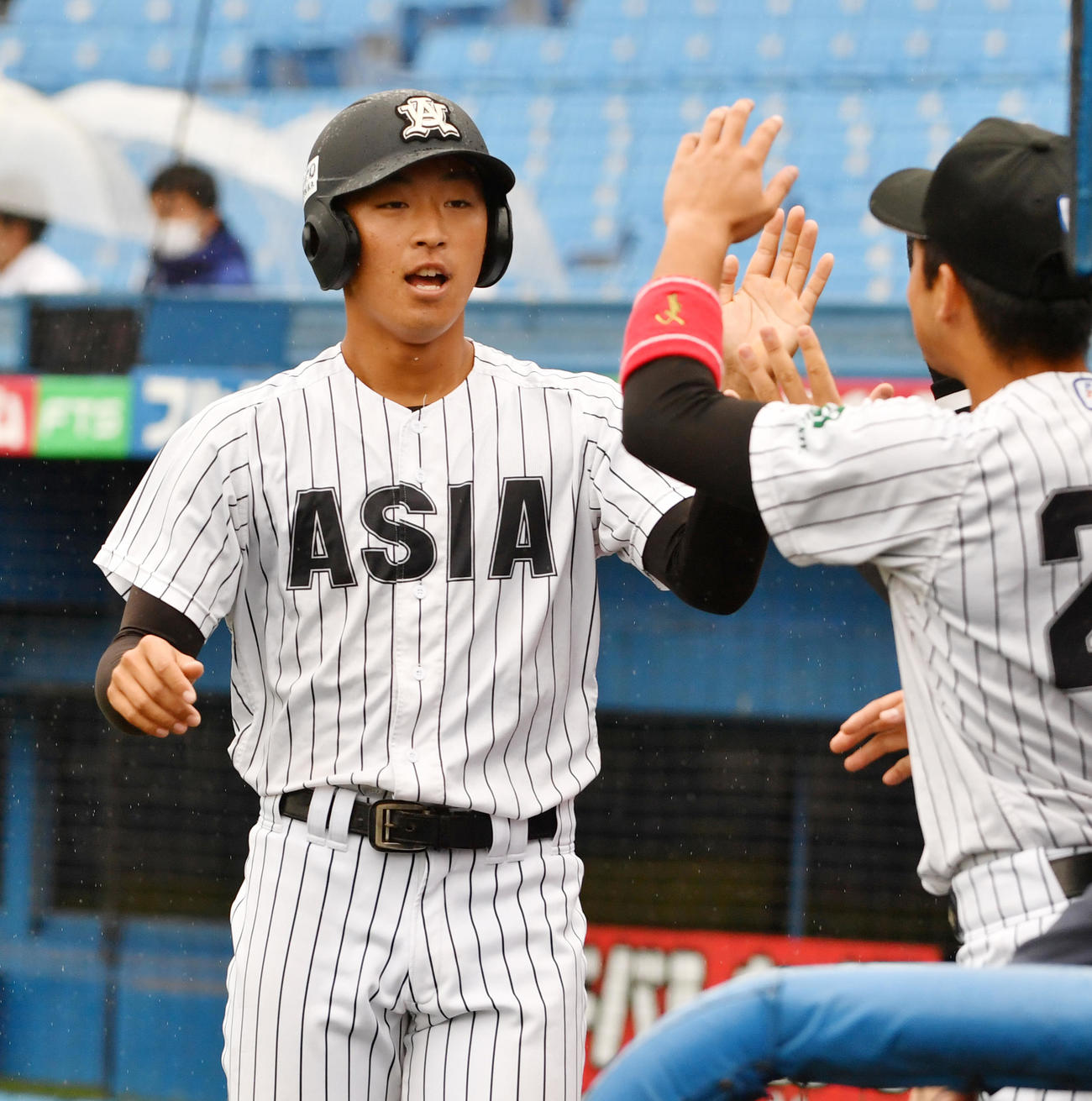 亜大対駒大　2回表亜大1死二塁、小山の右翼線適時二塁打で二塁走者右田が生還しナインの出迎えを受ける（撮影・柴田隆二）