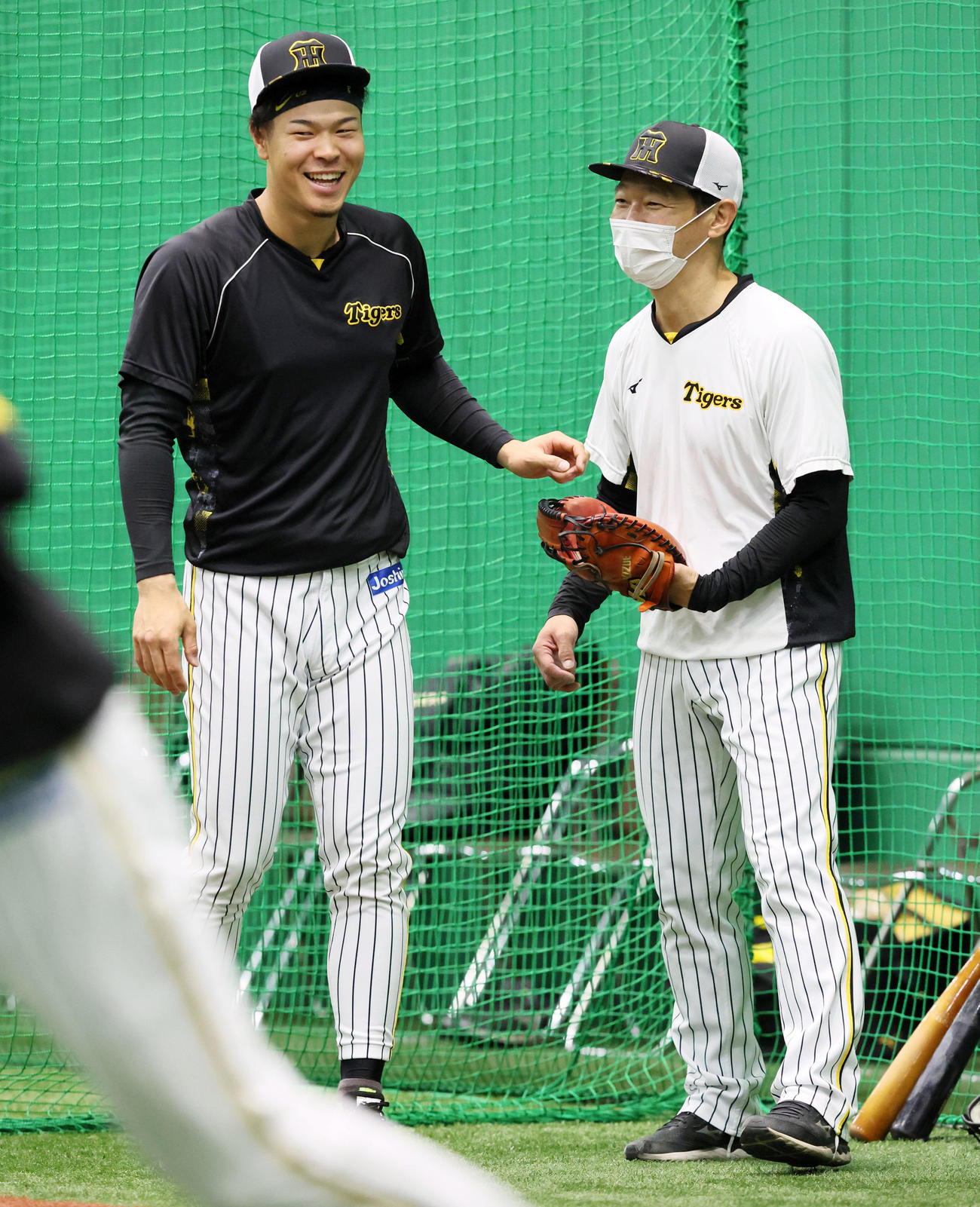 佐藤輝（左）は鈴衛ブルペン捕球と談笑する（撮影・加藤哉）