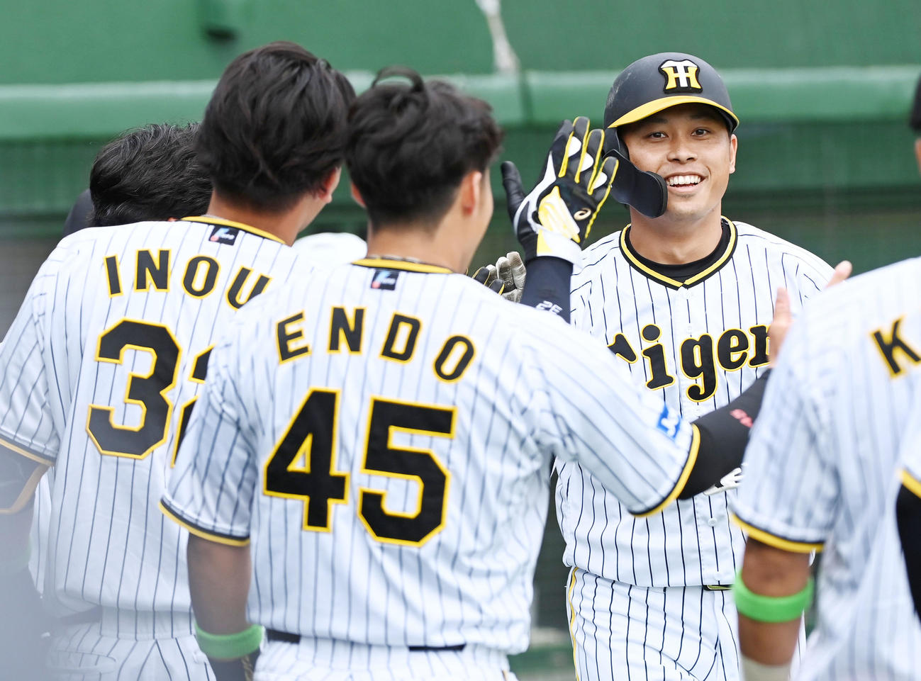 阪神対楽天　1回裏阪神無死、高山（右）は先制の右越え本塁打を放ちナインの祝福に笑顔を見せる（撮影・前岡正明）