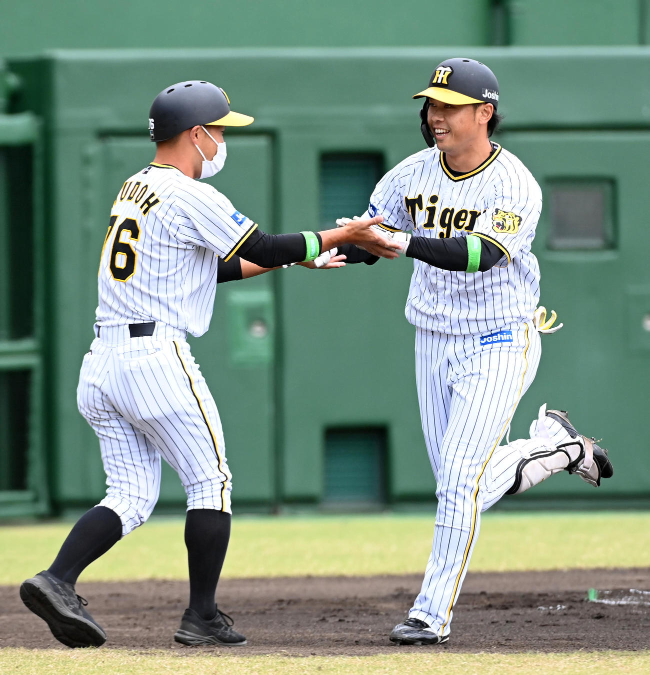 阪神対楽天　1回裏阪神無死、高山（右）は先制の右越え本塁打を放ち工藤コーチと笑顔でタッチ（撮影・前岡正明）